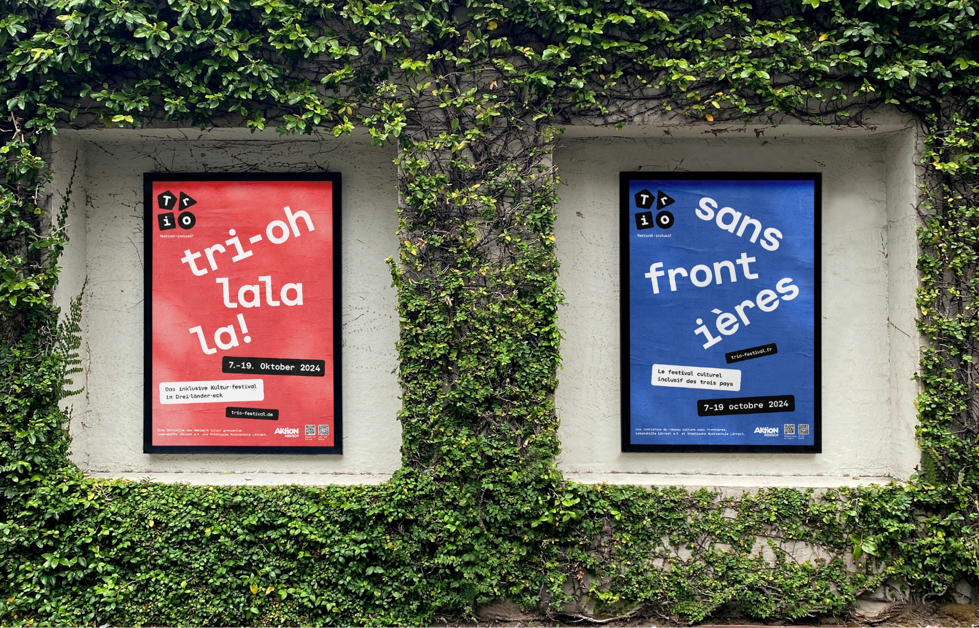 Bunte TRIO-Festival Plakate vor begrünter Wand
